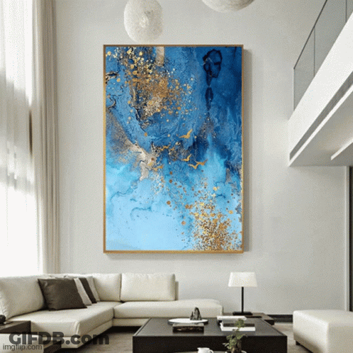 A Large Blue And Gold Painting Hangs Above A Couch GIF