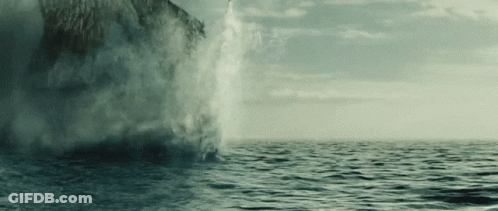 A Large Body Of Water Is Being Sprayed By A Large Rock GIF