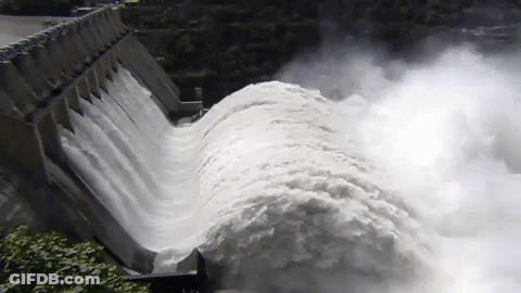 A Large Body Of Water Is Coming Down A Dam Wall GIF