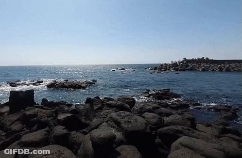 A Large Body Of Water Is Surrounded By Rocks GIF
