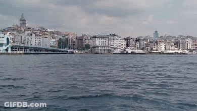 A Large Body Of Water Surrounded By Buildings With A City In The Background GIF