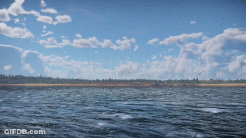 A Large Body Of Water With A Blue Sky And Clouds Behind It GIF