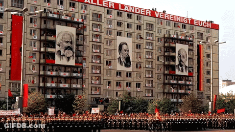 A Large Building With A Sign That Says " Aller Lander Vereinigt Euch " GIF