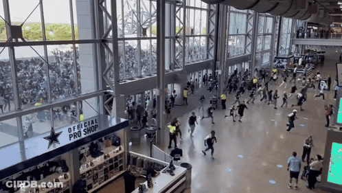 A Large Crowd Of People Are Gathered In Front Of An Official Pro Shop GIF