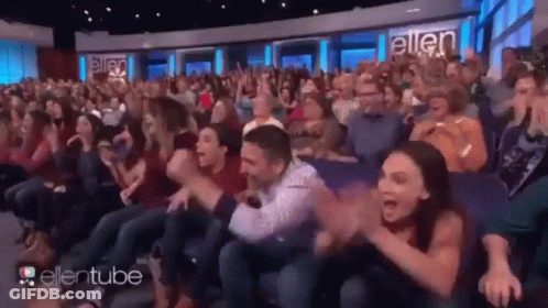 A Large Crowd Of People Are Sitting In A Theater Watching A Show Called Ellentube . GIF