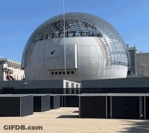 A Large Dome Shaped Building With A Sign That Says ' Academy Of Motion Picture Arts And Sciences ' On It GIF