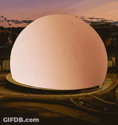 A Large Dome With A Lot Of Lights On It Is Lit Up At Night GIF