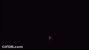 A Large Explosion Of Fire Is Coming Out Of The Ground In The Dark . GIF