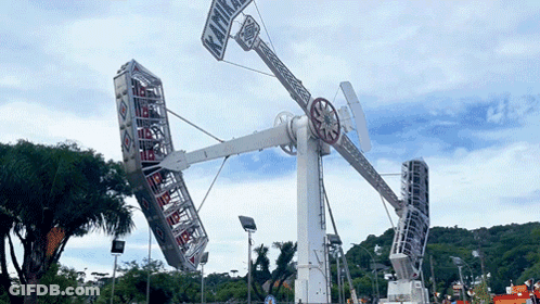A Large Ferris Wheel With A Sign On It That Says ' Kiwi ' On It GIF