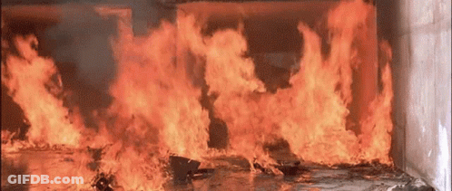 A Large Fire Is Burning In A Room With Smoke Coming Out Of It GIF