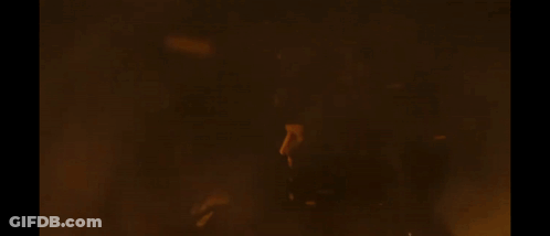 A Large Fire Is Burning In The Dark And A Person Is Standing In Front Of It . GIF