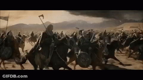 A Large Group Of Medieval Soldiers Are Riding Horses In A Field . GIF