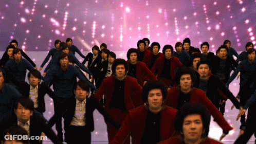 A Large Group Of People Are Dancing In Front Of A Purple Background GIF