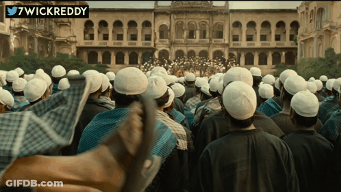 A Large Group Of People Are Gathered In Front Of A Building With A Twitter Username 7Wickreddy GIF