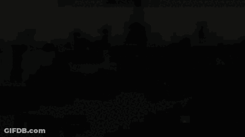 A Large Group Of People Are Gathered In Front Of A Large Building GIF