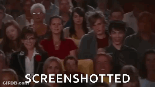 A Large Group Of People Are Sitting In A Theater Watching A Movie And The Words `` Screenshotted '' Are Displayed . GIF