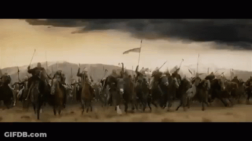 A Large Group Of Soldiers Are Riding Horses Through A Desert . GIF