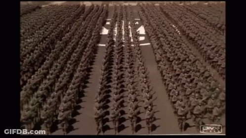 A Large Group Of Soldiers Marching Down A Street With A Divx Logo On The Bottom GIF