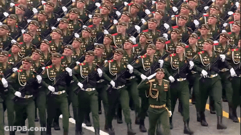 A Large Group Of Soldiers Marching In A Parade GIF