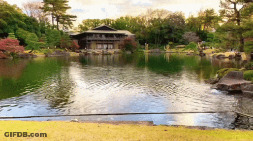 A Large House Sits On The Shore Of A Large Lake GIF