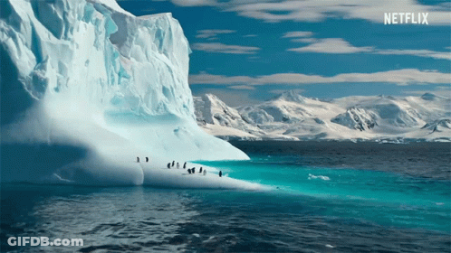 A Large Iceberg In The Middle Of The Ocean With Penguins On It And A Netflix Logo In The Background GIF