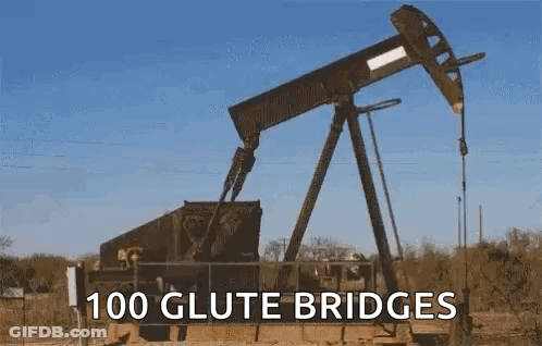 A Large Oil Pump In The Middle Of A Field With The Words `` 100 Glute Bridges '' Above It . GIF