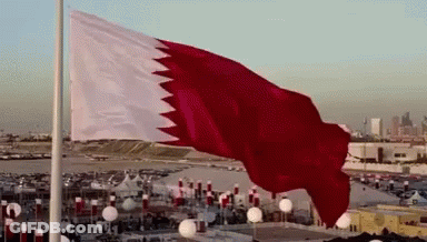 A Large Red And White Flag Flies In The Wind GIF