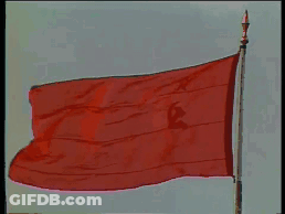 A Large Red Flag With A Hammer And Sickle On It Is Flying In The Wind GIF