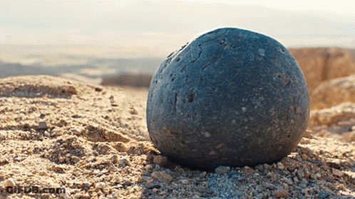 A Large Rock Is Sitting On Top Of A Pile Of Dirt GIF