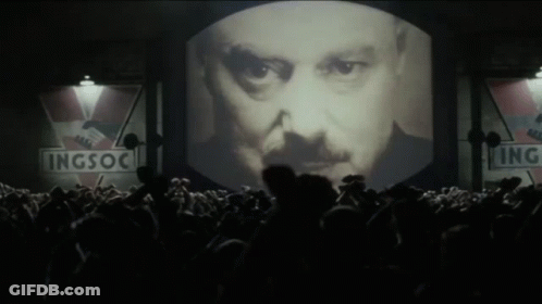 Large Screen Showing Man's Face With Signs GIF