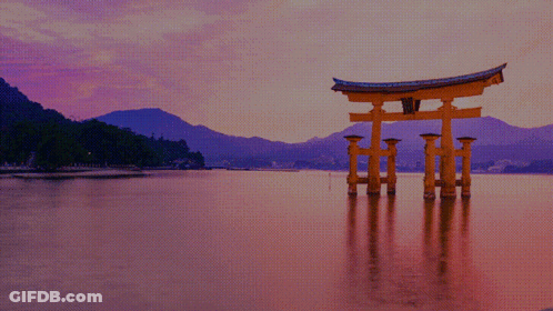 A Large Torii Gate Is In The Middle Of A Body Of Water GIF