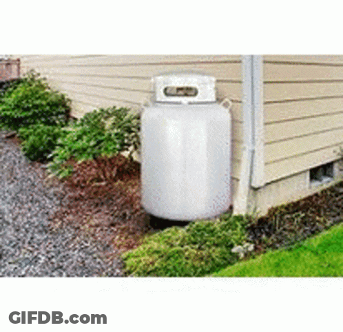 A Large White Propane Tank Is Sitting On The Side Of A House . GIF