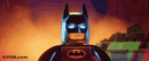 A Lego Batman With Glowing Eyes And A Bat Logo On His Chest GIF