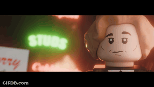 A Lego Character Is Standing In Front Of A Neon Sign That Says Studs GIF