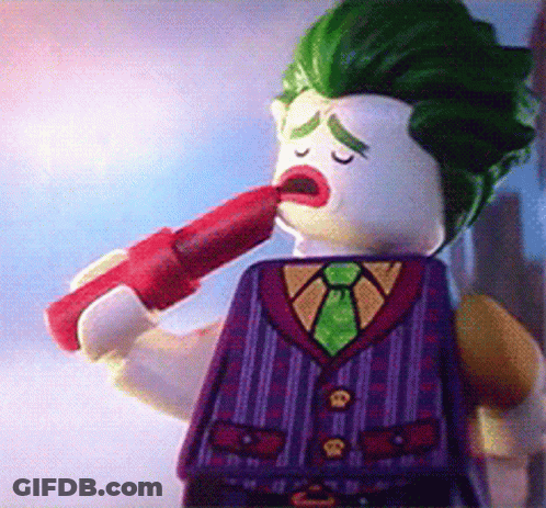 A Lego Figure Of The Joker Is Holding A Red Lipstick In His Mouth GIF