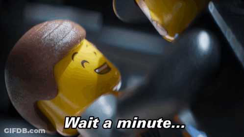 A Lego Figure Says " Wait A Minute " In A Dark Room GIF