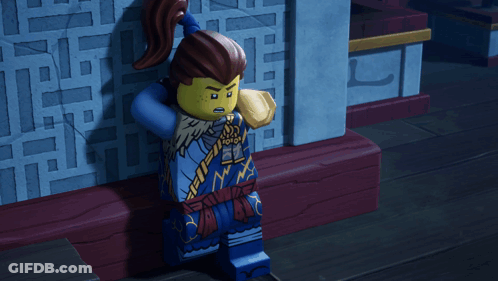 A Lego Figure Stands In Front Of A Wall With Chinese Writing On It GIF