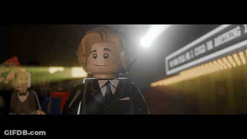 A Lego Man In A Suit And Tie Stands In Front Of A Sign That Says Evening Of Excellence GIF