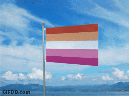 A Lesbian Flag Is Flying In Front Of A Blue Sky GIF