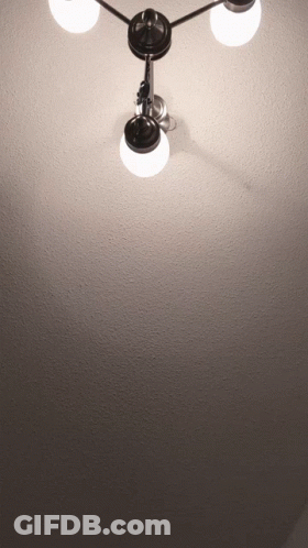 A Light Hanging From The Ceiling With Three Lights On It GIF