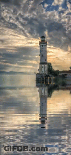 A Lighthouse Stands In The Middle Of A Body Of Water GIF