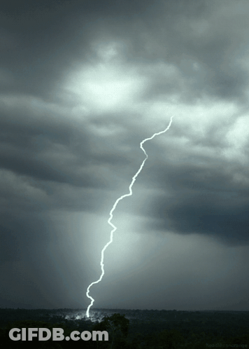 A Lightning Bolt Strikes The Ground In A Dark Sky GIF