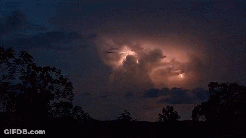 A Lightning Strike Is Visible In The Dark Sky GIF