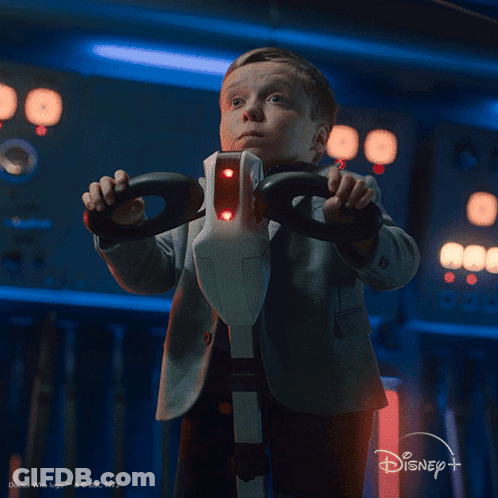 A Little Boy Holding A Steering Wheel With The Words What Is That Below Him GIF