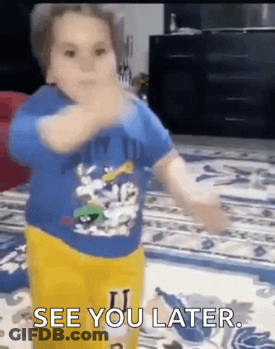 A Little Boy In A Blue Shirt And Yellow Pants Is Standing On A Rug And Says See You Later . GIF