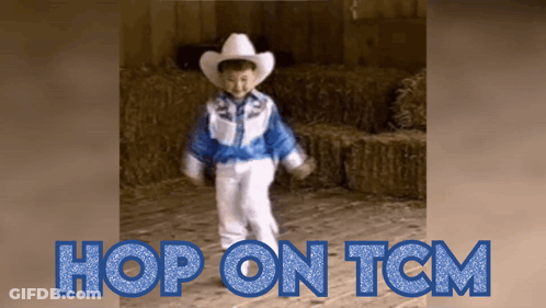A Little Boy In A Cowboy Outfit Is Dancing In Front Of Hay Bales GIF