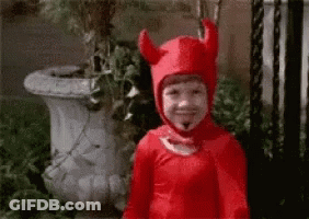 A Little Boy In A Devil Costume Is Smiling GIF