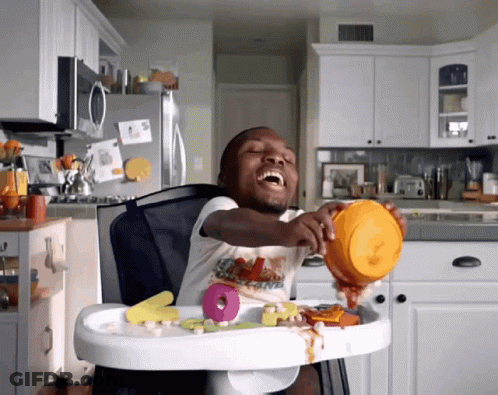 A Little Boy In A High Chair With A Bowl Of Food GIF