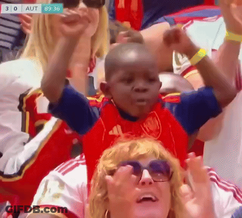 A Little Boy In A Red Adidas Shirt Is Sitting On A Woman 'S Shoulders GIF