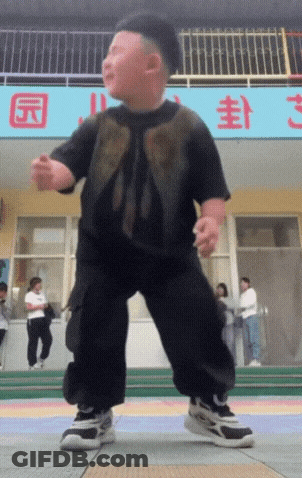 A Little Boy Is Dancing In Front Of A Sign That Says ' S ' On It GIF